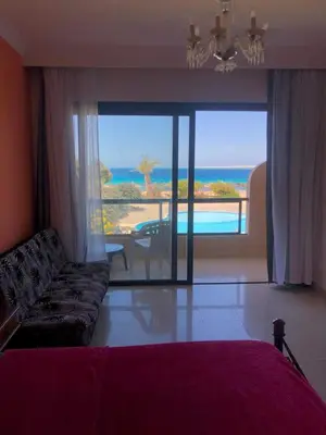 a living room with a couch and a view of the ocean at Navy Chalets 107 in Hurghada