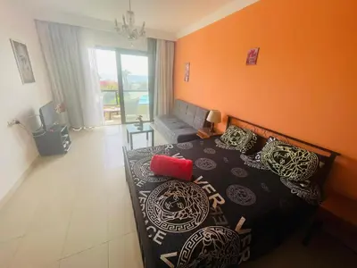 a bedroom with a bed with an orange wall at Navy Chalets 107 in Hurghada