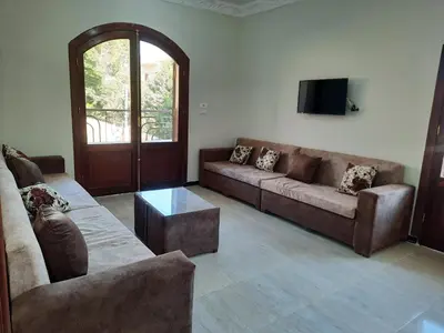 a living room with two couches and a tv at The royal flat for rent in Al Qurnah