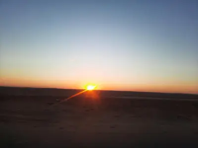a sunset in the middle of the desert at The royal flat for rent in Al Qurnah