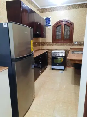 a kitchen with a stainless steel refrigerator and a stove at The royal flat for rent in Al Qurnah