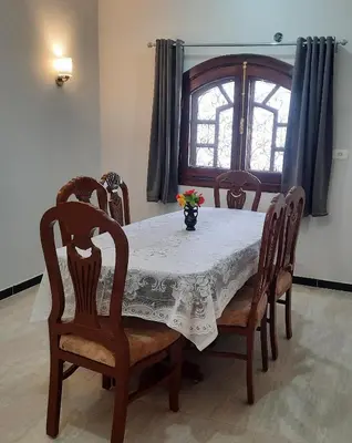 a dining room table with a vase of flowers on it at The royal flat for rent in Al Qurnah