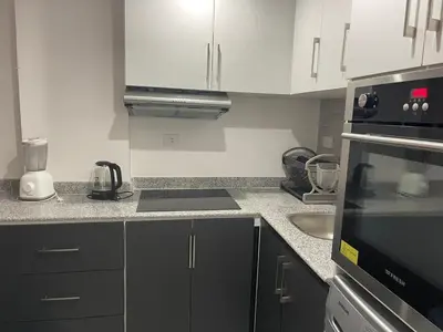 a kitchen with black and white cabinets and a sink at Marina City portghalib one bedroom in Port Ghalib