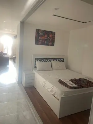a bedroom with a white bed with a painting on the wall at Marina City portghalib one bedroom in Port Ghalib