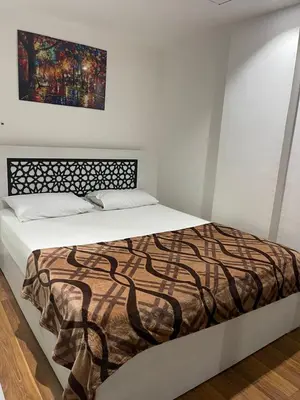 a bed in a bedroom with a painting on the wall at Marina City portghalib one bedroom in Port Ghalib