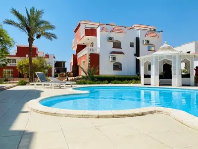 a swimming pool with a gazebo and a building at Hurghada- Magawish Studio 3 in Hurghada