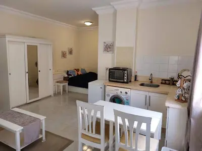 a kitchen and living room with a table and chairs at Nice Studio in Elegant Compound Intercontinental Area in Hurghada