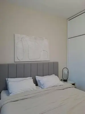 a bed with white pillows and a painting above it at Luxury in the heart of Gouna in Hurghada