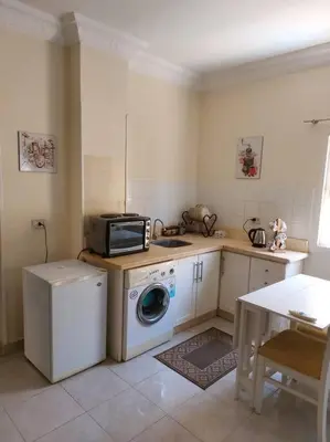 a kitchen with a washing machine and a microwave at Cozy/Comfy Studio at Intercontinental Area in Hurghada