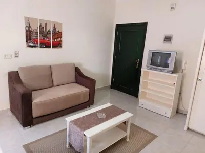 a living room with a couch and a tv at Cozy/Comfy Studio at Intercontinental Area in Hurghada