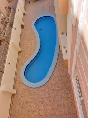 a blue swimming pool in the middle of a building at Cozy/Comfy Studio at Intercontinental Area in Hurghada