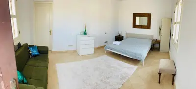 a bedroom with a bed and a couch and a mirror at CozY Condo in Hurghada