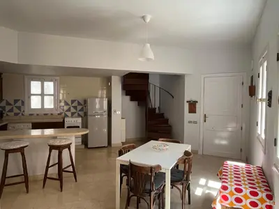a kitchen with a table and some chairs in a room at CozY Condo in Hurghada