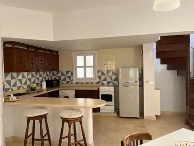a kitchen with a table and some stools in it at CozY Condo in Hurghada