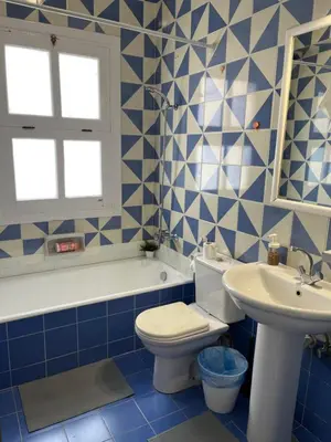 a blue and white bathroom with a toilet and a sink at CozY Condo in Hurghada