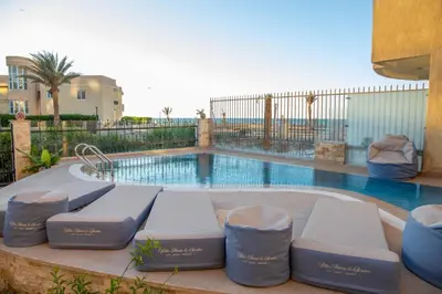 a pool with chairs and a swimming pool at Villa Anna & Snake in Hurghada