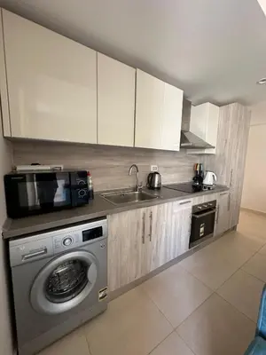 a kitchen with a washing machine and a microwave at Mangroovy 1br Charming Escape Hilton pool view in Hurghada