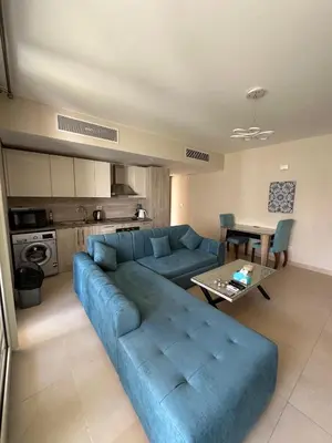 a living room with a blue couch and a table at Mangroovy 1br Charming Escape Hilton pool view in Hurghada