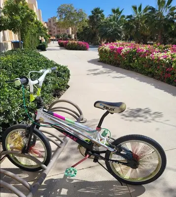a bike parked on a sidewalk in front of flowers at Mangroovy 1br Charming Escape Hilton pool view in Hurghada