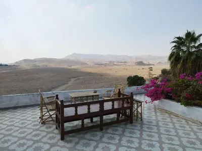 a patio with a table and chairs and a view of the desert at Gabawy Garden, Privatzimmer mit zwei Einzelbetten in Luxor