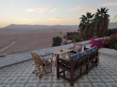 a patio with a table and chairs and a view of the desert at Gabawy Garden, Privatzimmer mit zwei Einzelbetten in Luxor