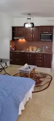 a living room with a table and a kitchen at Palma Resort in Hurghada