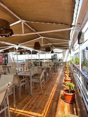 a restaurant with tables and chairs and potted plants at Luxor Aswan Coral 2 Nile Cruise every Saturday from Luxor 4 nights & every Wednesday from Aswan 3 nights in Luxor