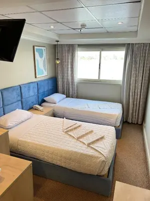 a hotel room with two beds and a tv at Luxor Aswan Coral 2 Nile Cruise every Saturday from Luxor 4 nights & every Wednesday from Aswan 3 nights in Luxor
