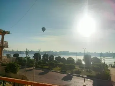 a hot air balloon flying over the water at Top View in Luxor